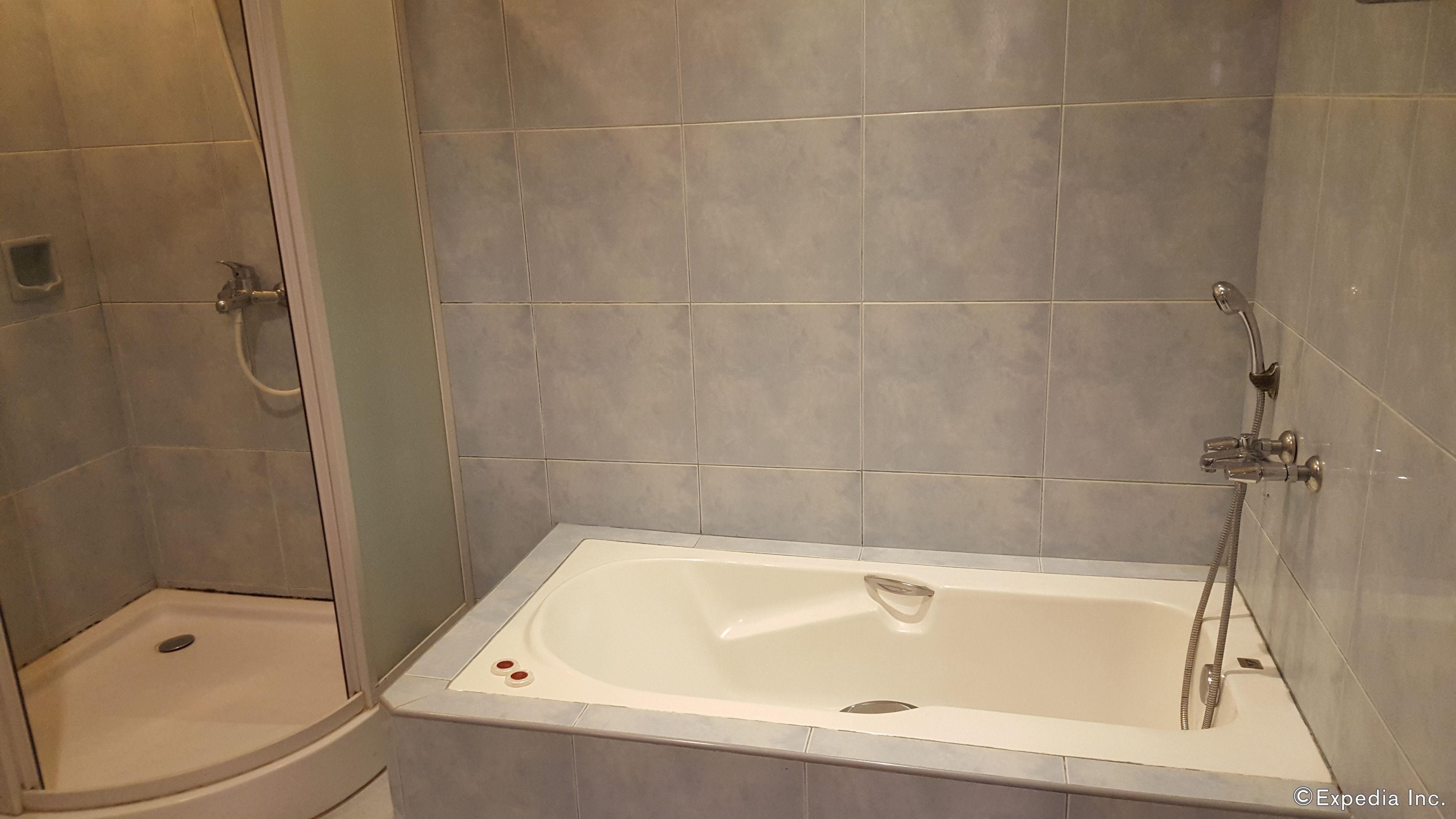 A bathroom with a bathtub and a shower area.
