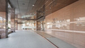 Una entrada de hotel moderna con suelo de baldosas y fachada de vidrio.