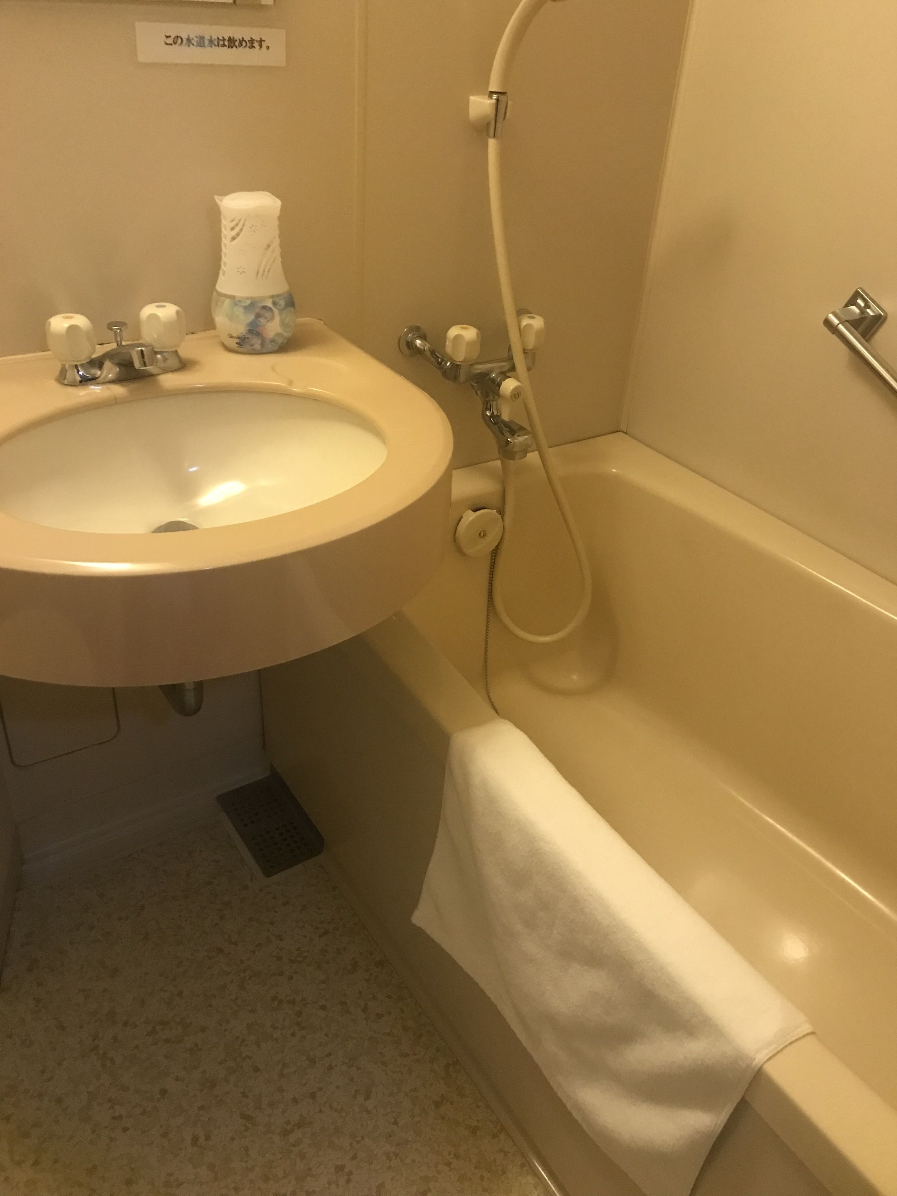 Un baño con lavamanos, grifo y ducha.
