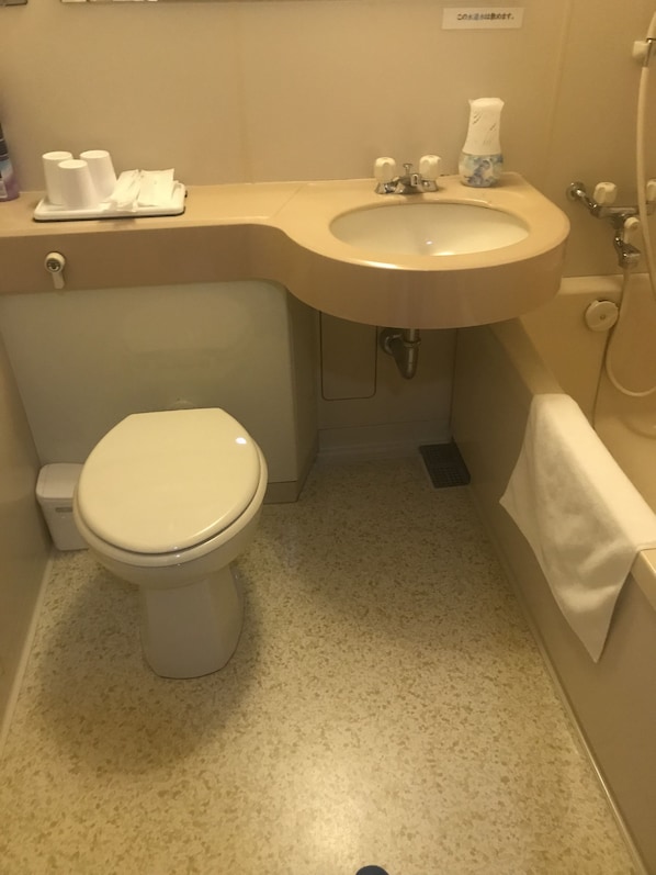 Un baño pequeño con inodoro, lavabo y ducha.