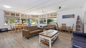 A spacious living area with a dining set, sofas, and a coffee table. - Reflections Eden - Holiday Park (Eden)