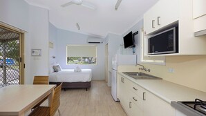 A compact hotel room with a kitchenette, a bed with a view, and a dining area. - Reflections Eden - Holiday Park (Eden)