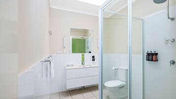 Ein modernes Badezimmer mit Duschkabine aus Glas, einem weißen Waschbecken und einer Toilette.