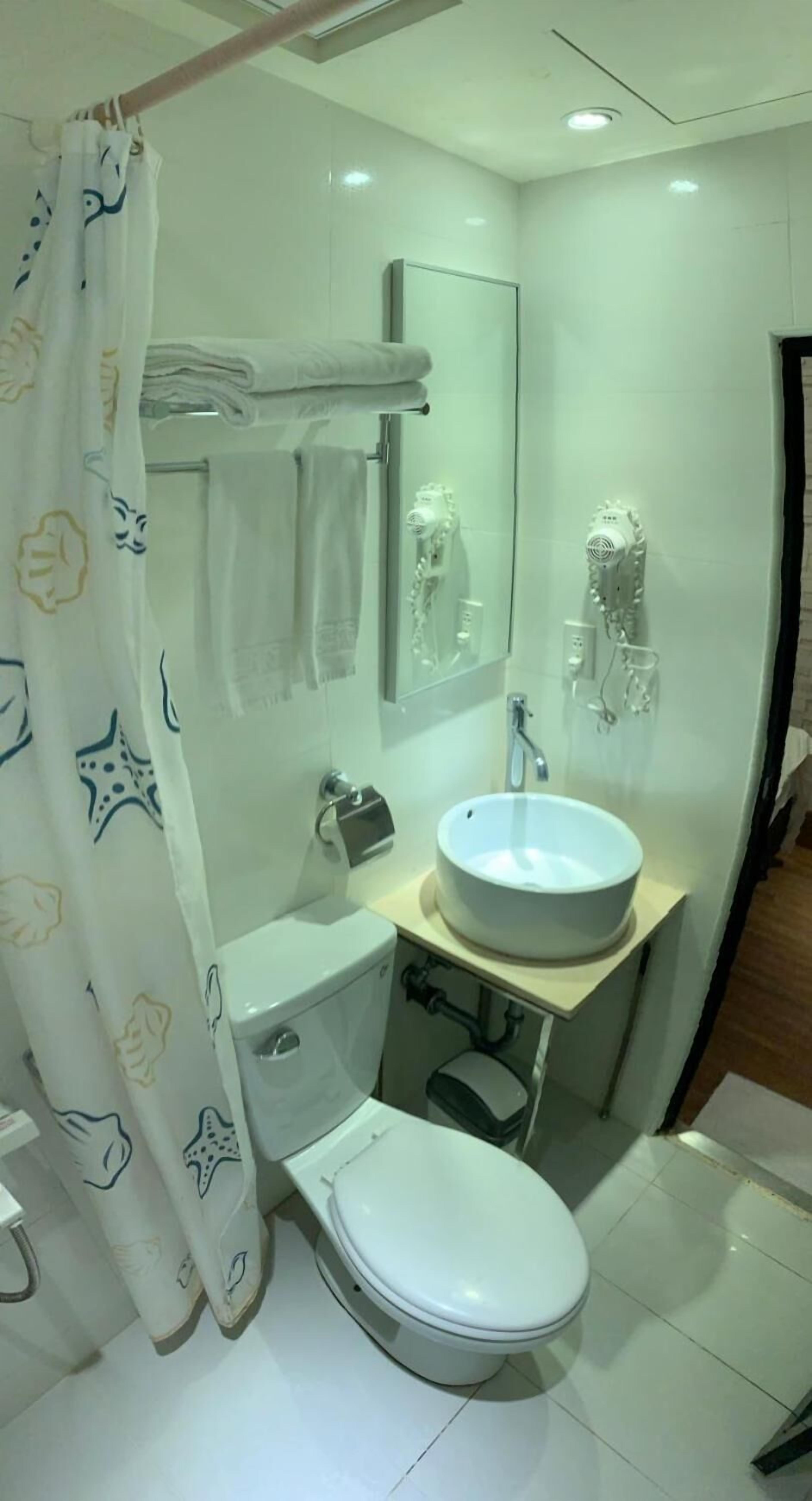 A modern bathroom with a toilet, sink, and shower area.
