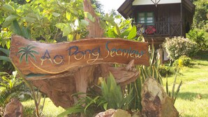 A wooden sign with palm tree illustrations and the text "Ao Pong Seaview". - AoPong Resort (Ko Mak)