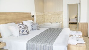 Ein modernes Hotelzimmer mit einem großen Bett, einer Badewanne und einem hölzernen Kopfteil.