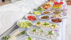 Ein Buffet mit verschiedenen Speisen, darunter Obst, Gemüse und Käse.