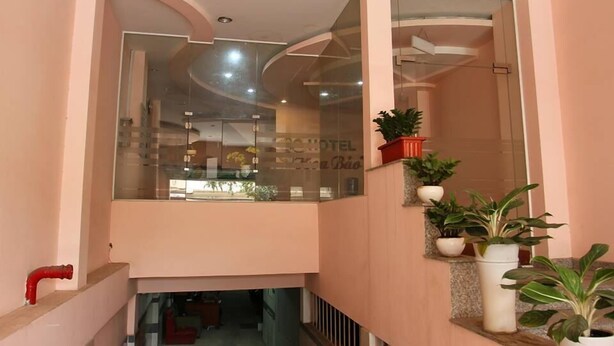 Un hall d’hôtel doté d’un plafond incurvé, de murs en verre et de plantes en pot.