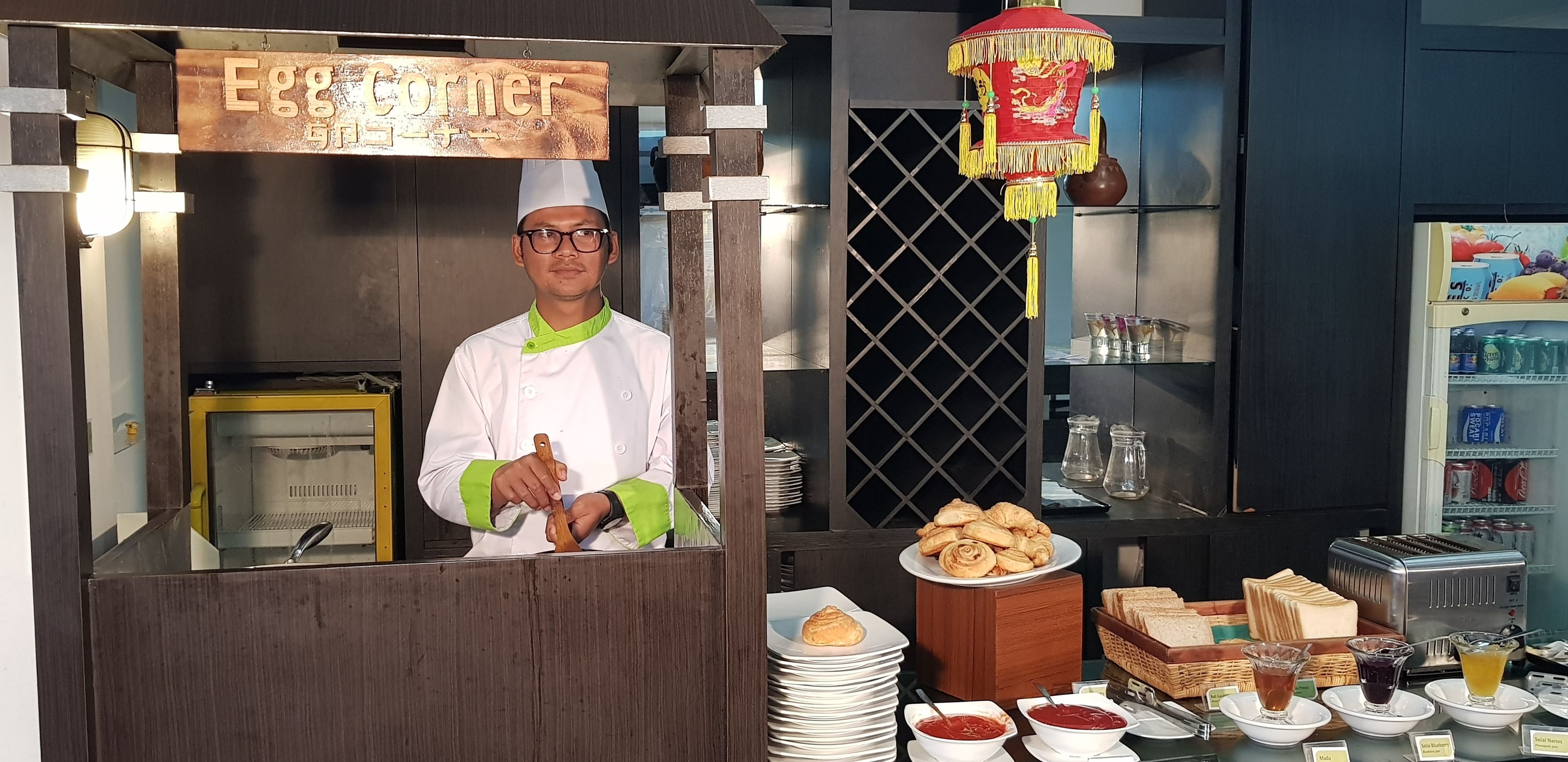 Un buffet proposant une variété de plats, notamment des pâtisseries et du pain, ainsi qu’un panneau indiquant l’emplacement du buffet.