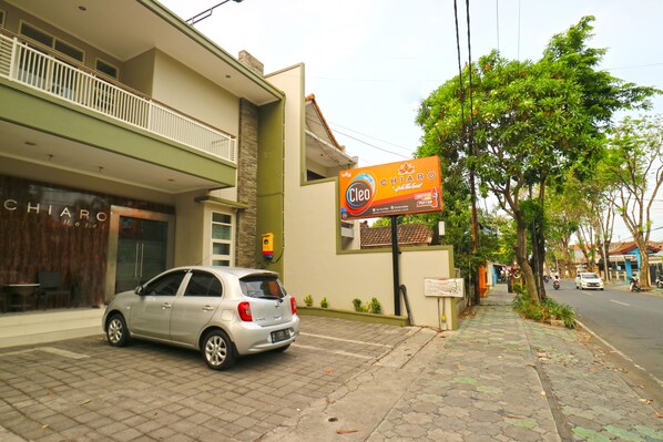 A building with a sign for 'Cleo' and a car parked in front. - Chiaro Hotel Syariah (Sidoarjo)