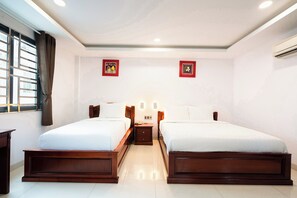 A hotel room with two beds, a window with curtains, and two wall-mounted artworks. - Hoang Hoang Hotel (Ho Chi Minh City)