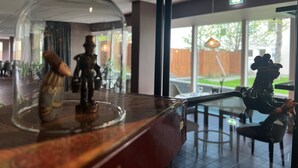A glass-top table with a decorative item and a statue. - Hotel Bifrost (Borgarbyggd)
