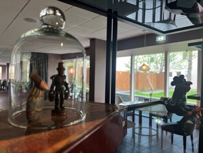 A glass-top table with a decorative item and a statue. - Hotel Bifrost (Borgarbyggd)