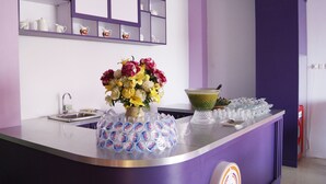 Una reception viola con un vaso di fiori, una ciotola e una pila di bicchieri.