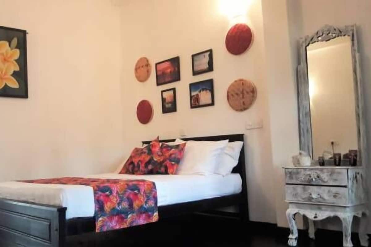 A bedroom with a bed, a dresser, and a mirror.