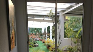 Un escalier donnant sur un jardin, visible à travers une fenêtre.