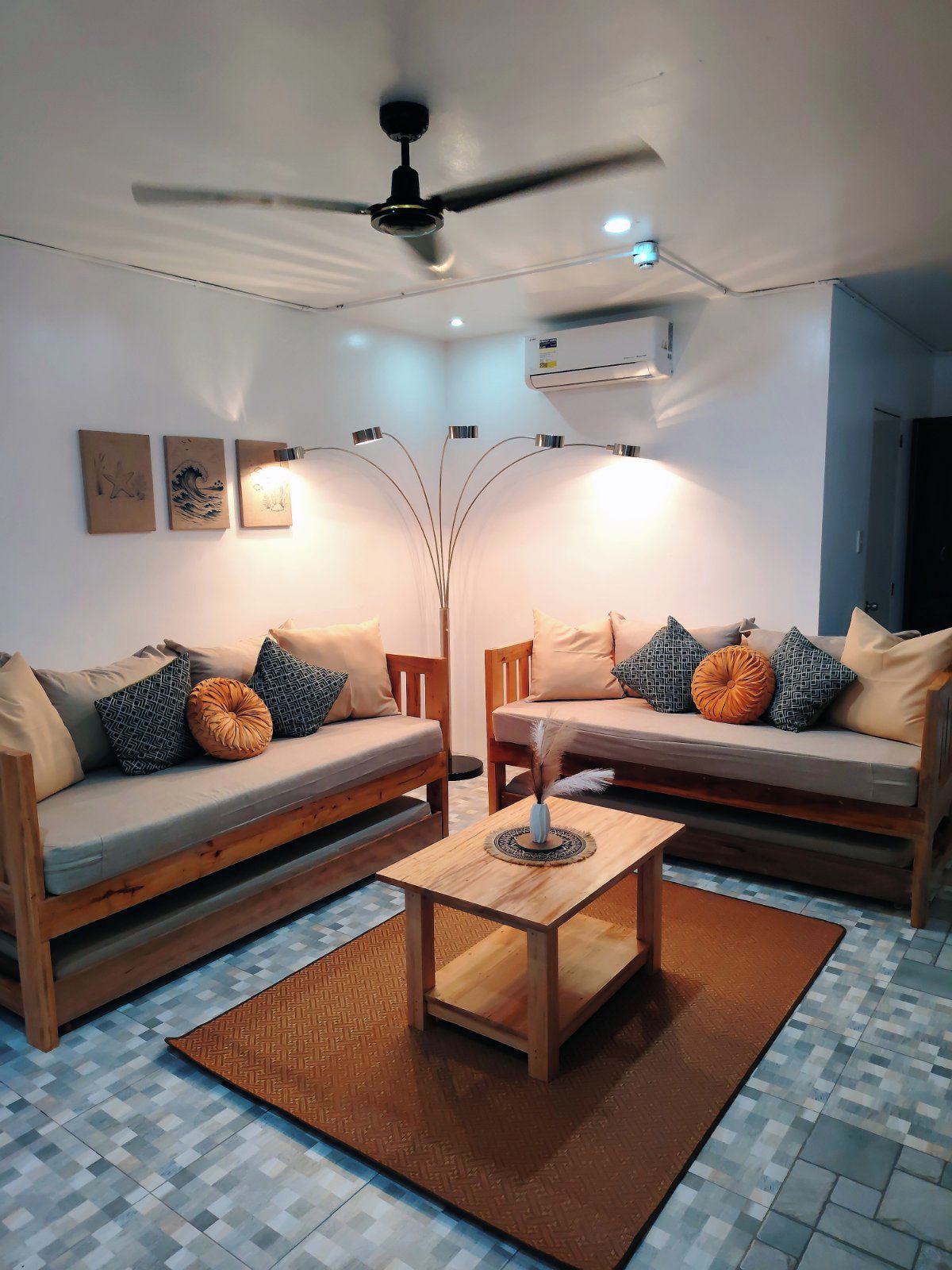 A living room with two sofas, a coffee table, a floor lamp, and wall art.