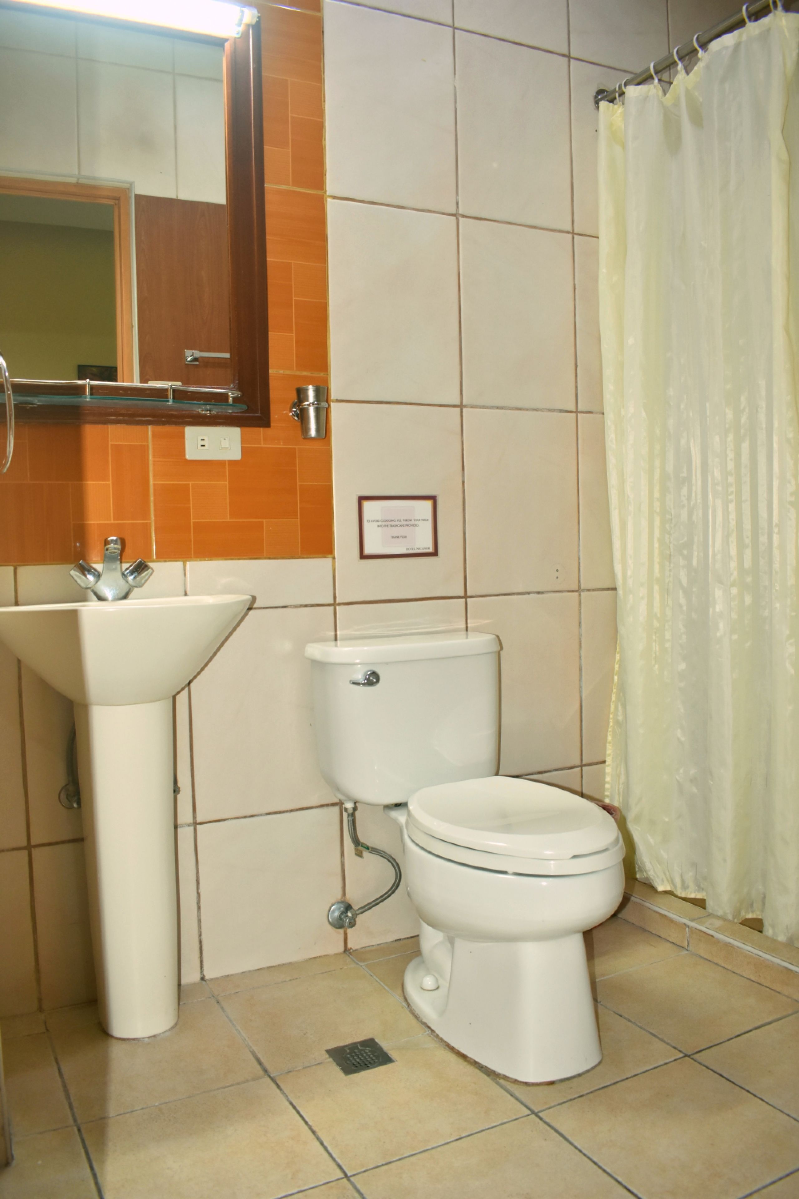 A bathroom with a sink, toilet, and a shower curtain.