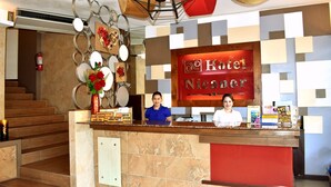 Een hotel receptiebalie met een bord waarop 'Hotel Nicaror' staat.