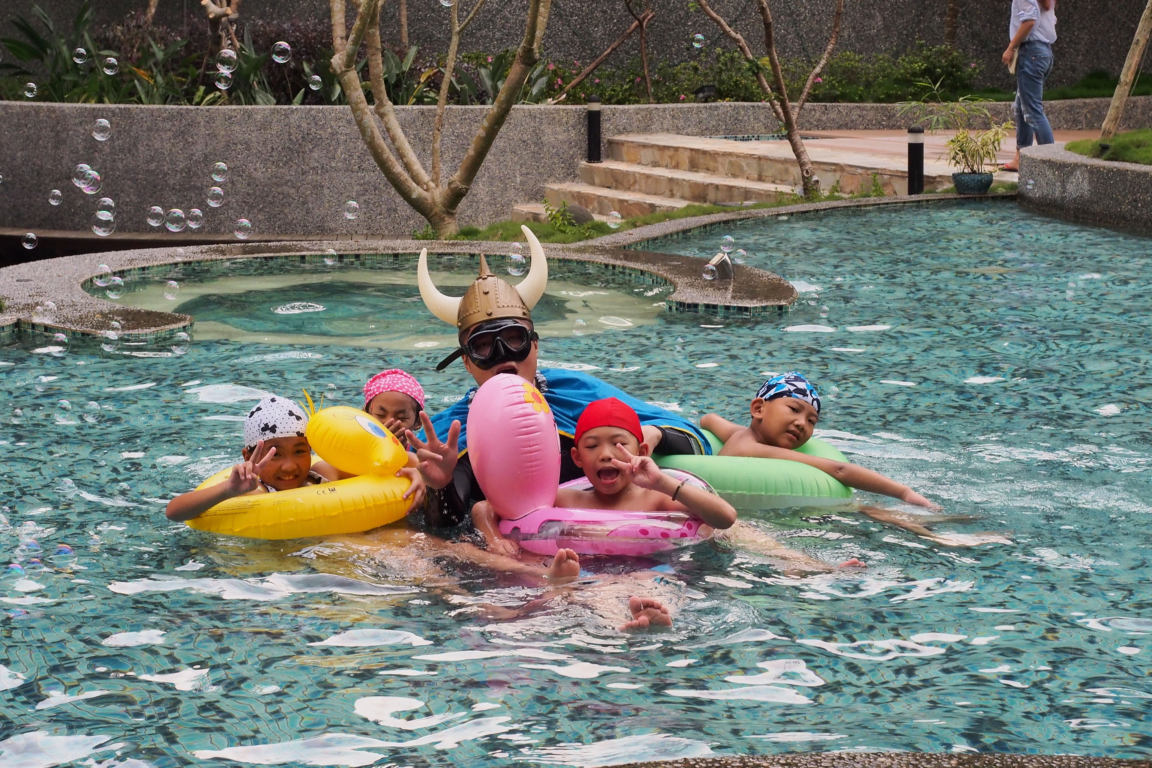 Una piscina al aire libre, sombrillas, sillones reclinables de piscina