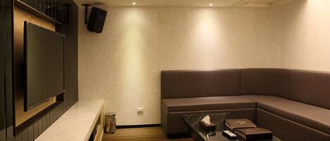 A modern living room with a flat-screen TV, a sectional sofa, and a coffee table.