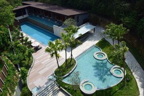 A modern house with a large rectangular swimming pool and a smaller circular pool.