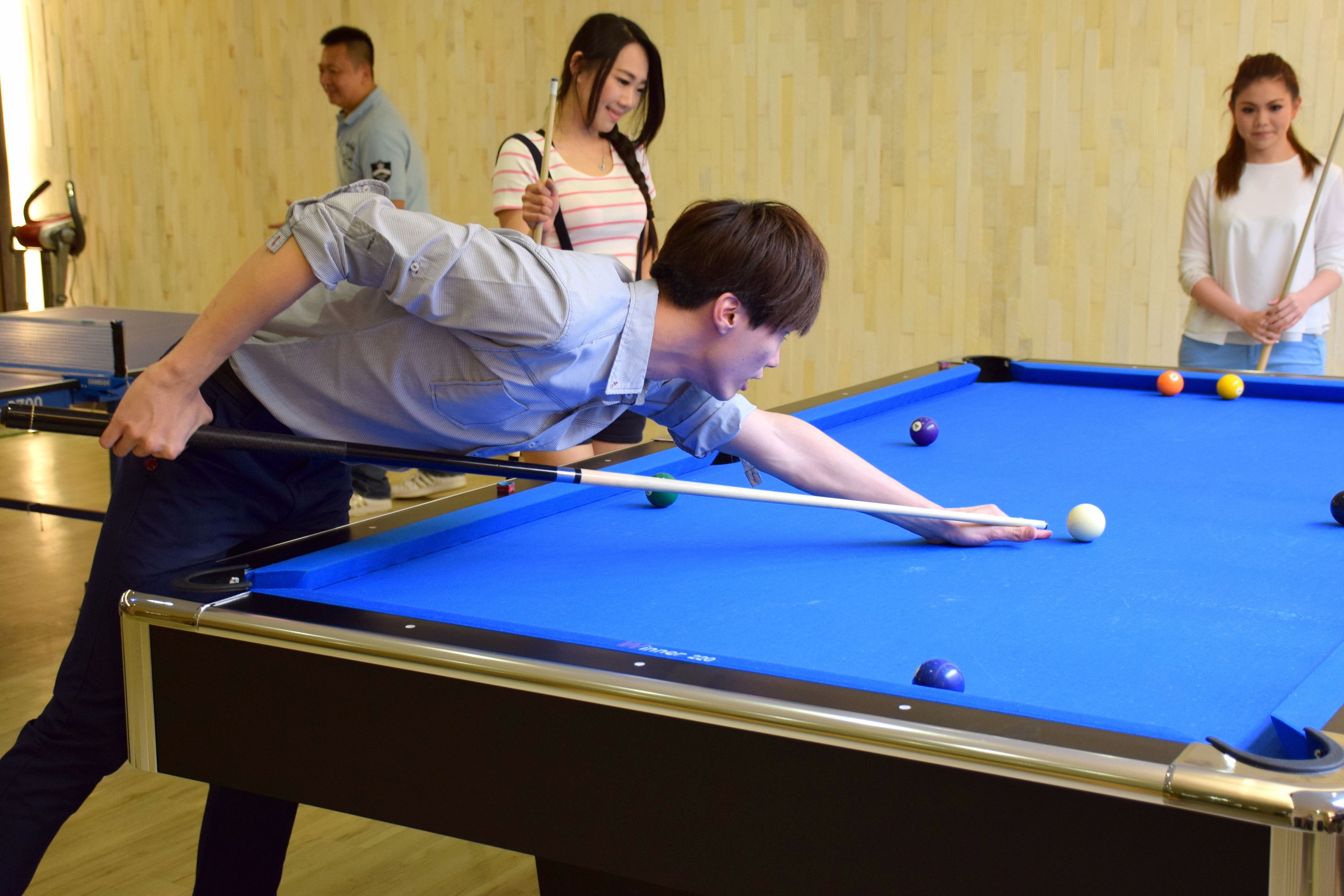 A pool table with balls and a cue stick.