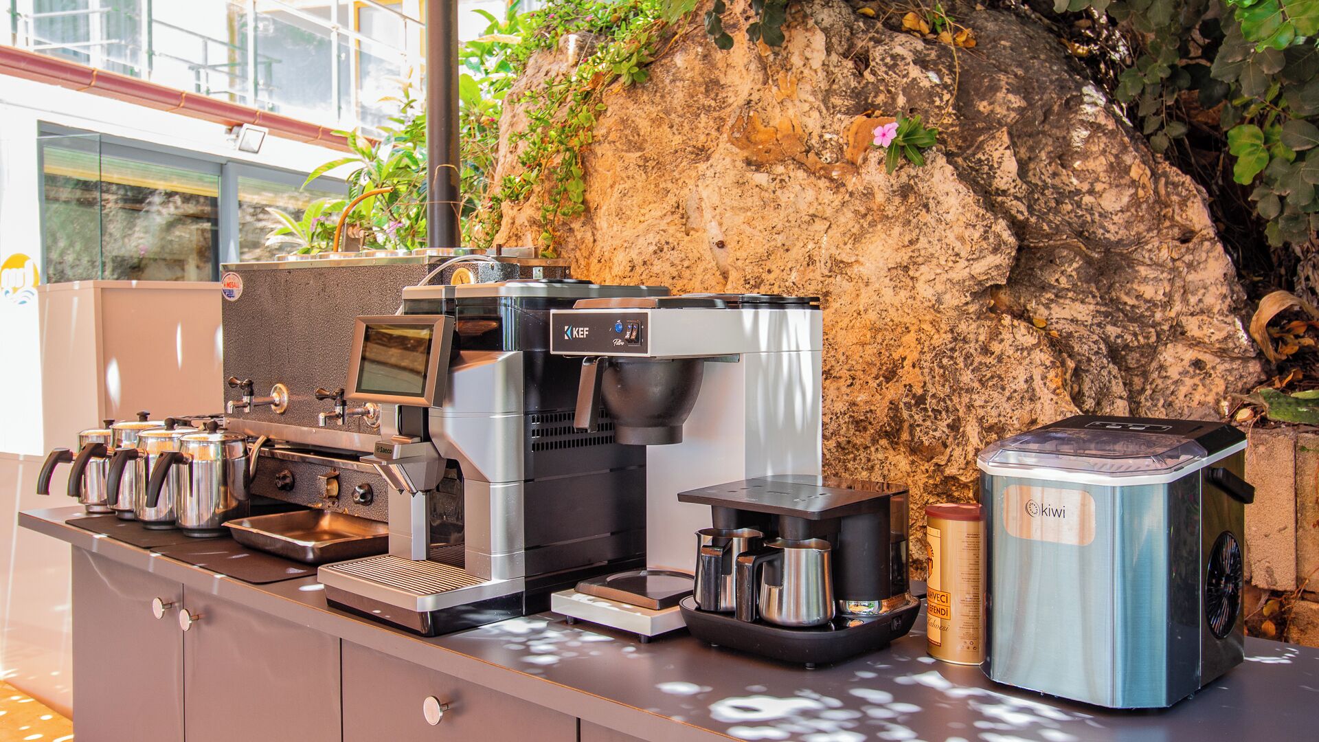 Een koffiehoek met meerdere espresso machines, een weegschaal en een melkopschuimer.