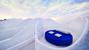 A snow-covered landscape with a unique, curved bed structure and a clear sky. - Ohana Resort and Restaurant (Rayong)