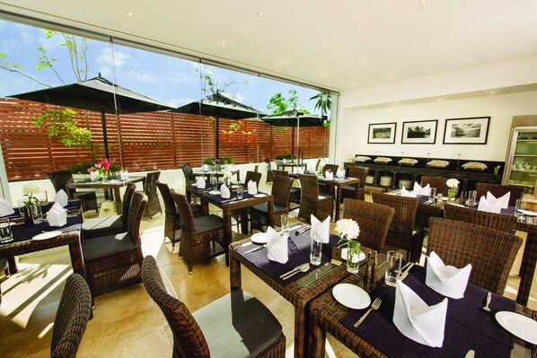 A restaurant with outdoor seating, wicker furniture, and a view of the sky. - Fair View Hotel Colombo (Colombo)