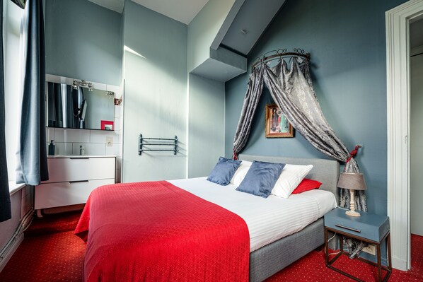A bedroom with a bed, bedside table, and a window with curtains. - Hotel Van Eyck (Bruges)