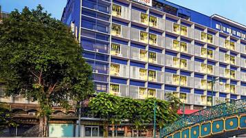 Un hotel de varios pisos, con balcones y un puente sobre el agua.