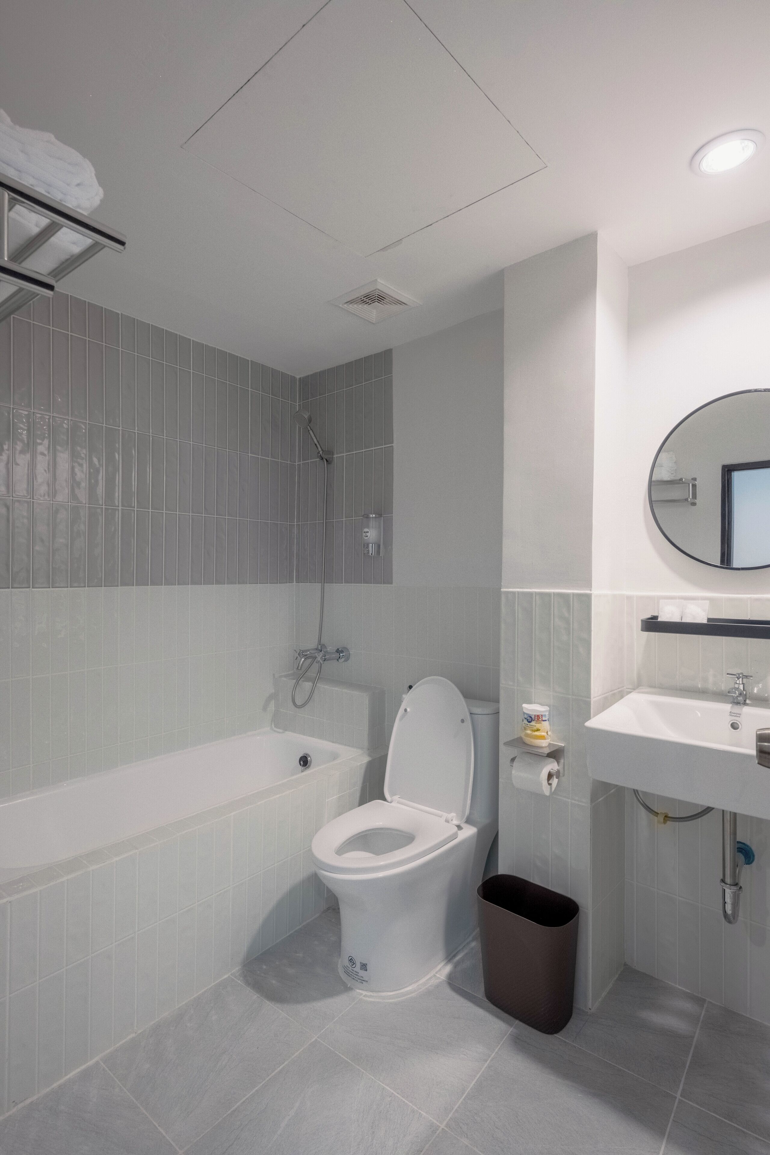 A modern bathroom with a bathtub, toilet, and sink.