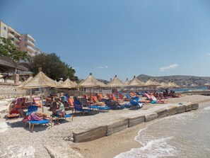 En la playa, camastros, sombrillas y toallas de playa 