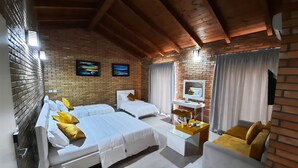Una habitación de hotel con dos camas, un escritorio, un televisor y un sofá.