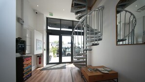 A modern interior with a spiral staircase, a wooden bench, and a fire extinguisher. - HDG Appart's Hotel Gare de L'Isle Adam (Parmain)