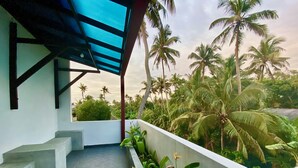 A balcony with a view of palm trees and a clear sky. - Tamara Motels (Hikkaduwa)