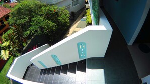 A modern building with a white facade, a tiled entrance, and a green lawn. - Tamara Motels (Hikkaduwa)