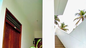 A staircase leading to an upper level, a wooden door, and a potted plant in the foreground. - Tamara Motels (Hikkaduwa)