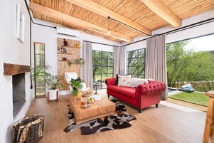 A modern living room with a red sofa, wooden coffee table, and a fireplace.