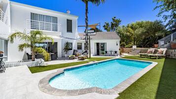 Enjoy a refreshing swim in the backyard pool surrounded by a well-maintained lawn and comfortable seating areas.