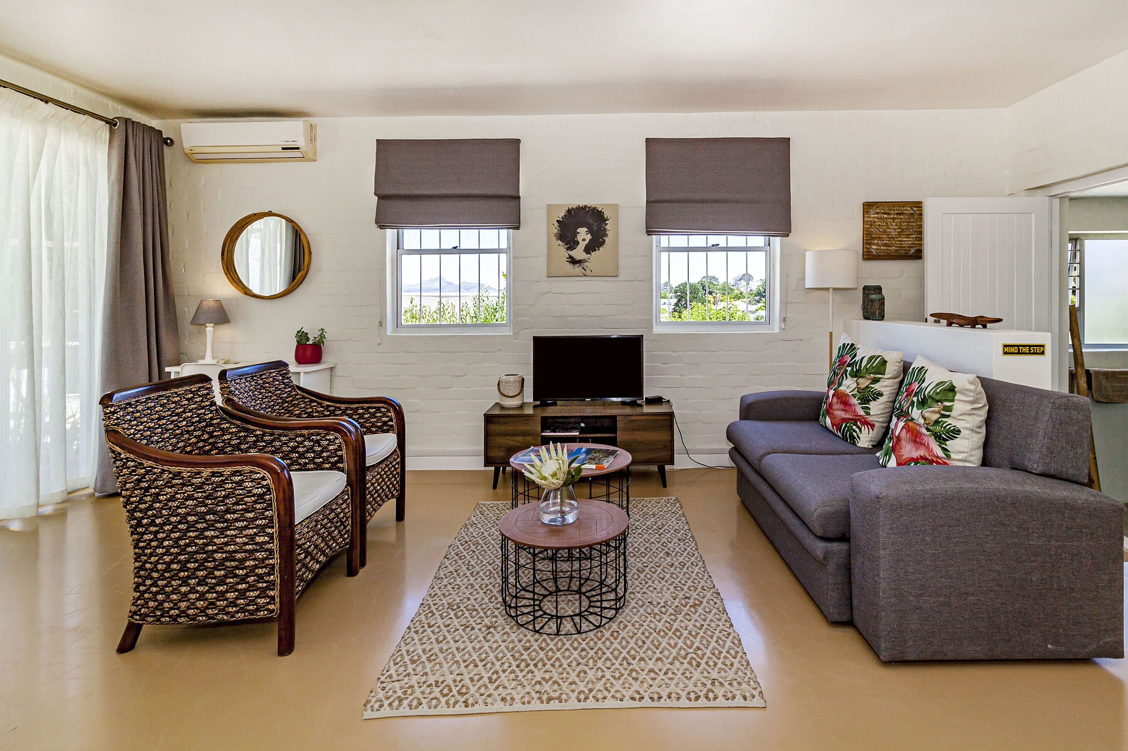 A living room with a sofa, two armchairs, a coffee table, a TV, and a fireplace.