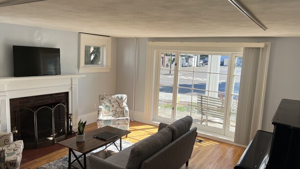 A living room with a fireplace, a sofa, a coffee table, and a TV.
