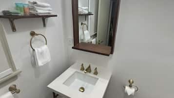 A bathroom with a white sink, a mirror, and a towel rack.