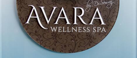 A circular sign with the name "AVARA WELLNESS SPA" and contact information.