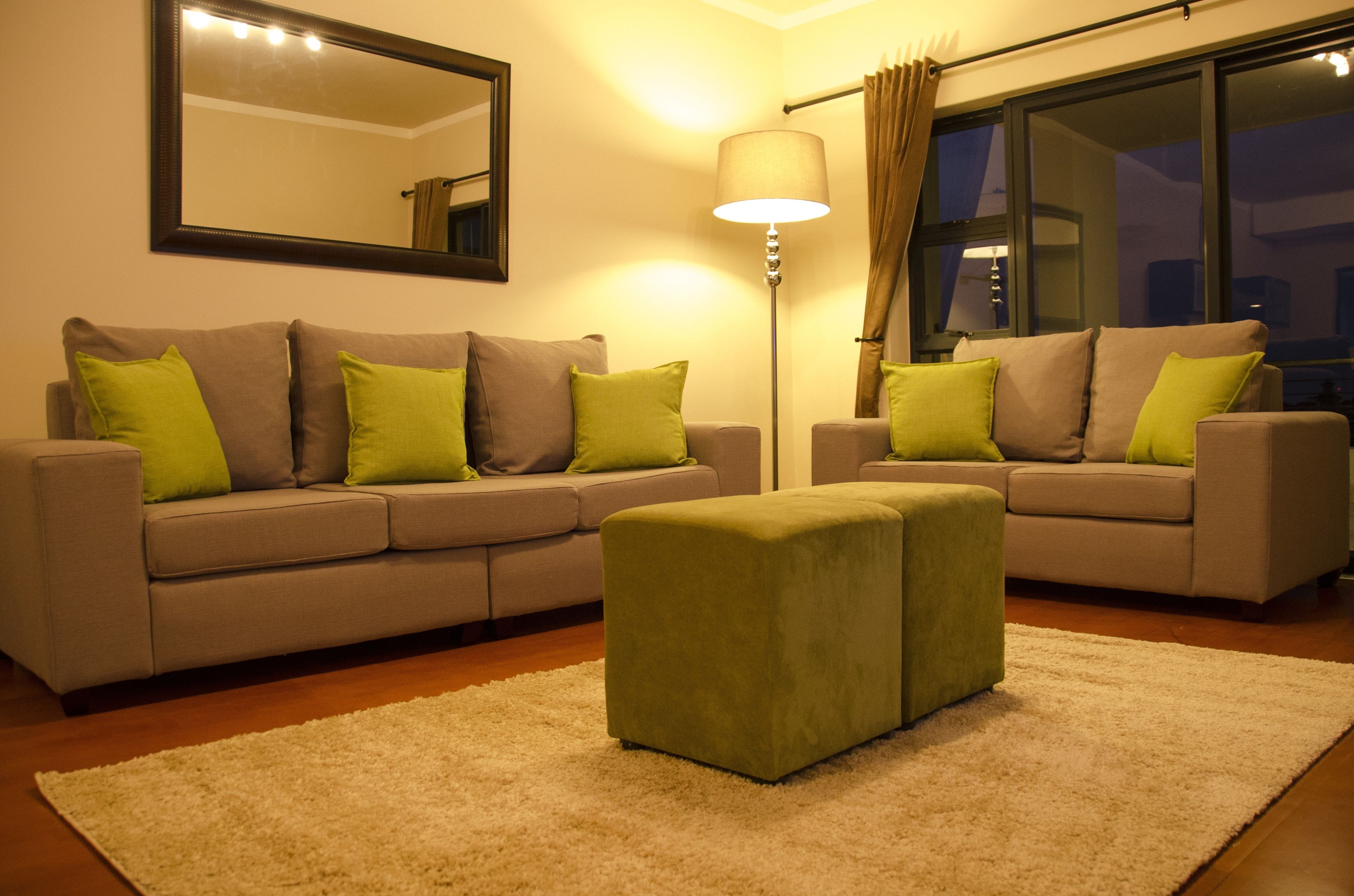 A living room with two sofas, a floor lamp, and a large window with curtains.