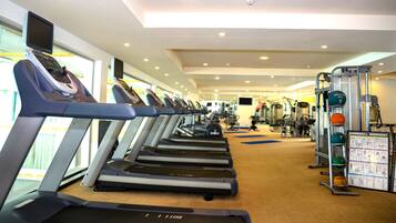 A gym with treadmills, weight machines, and a treadmill with a screen.