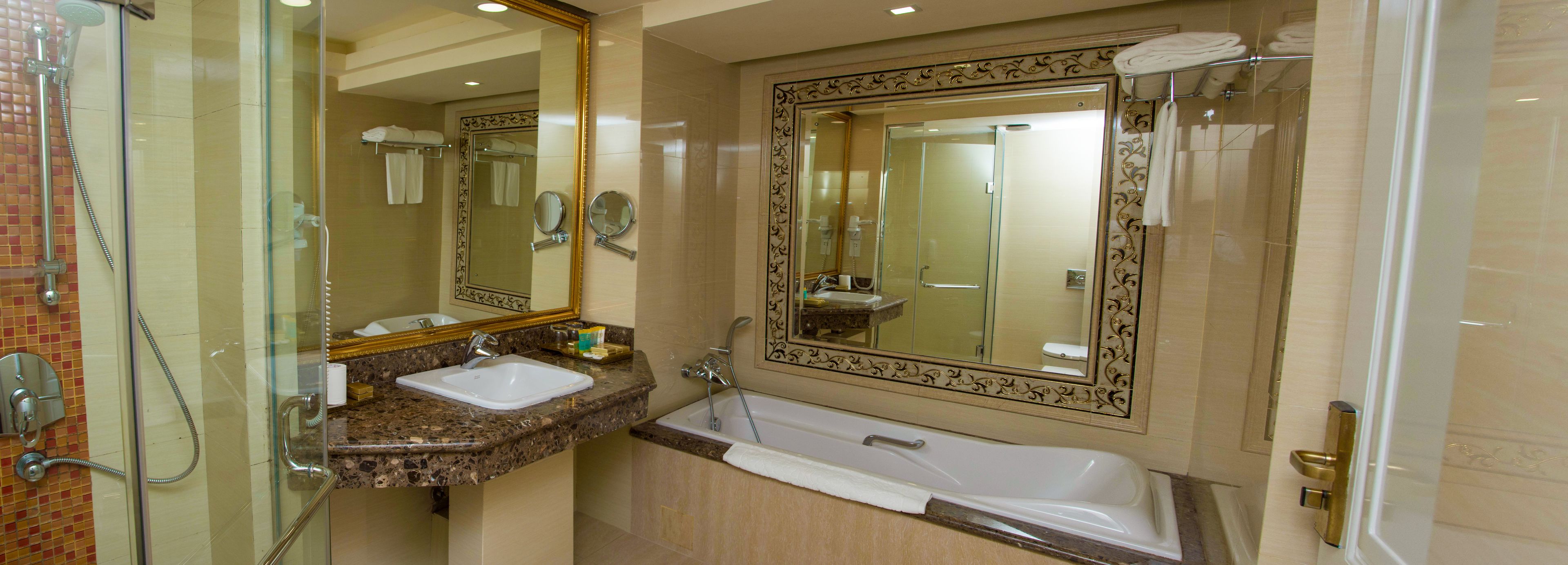 A bathroom with a glass-enclosed shower, a sink, and a bathtub.