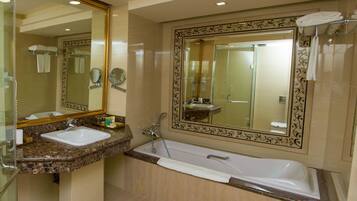 A bathroom with a glass-enclosed shower, a sink, and a bathtub.