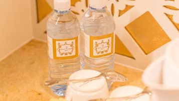 Una bandeja de desayuno con agua embotellada, una jarrón y diversos alimentos.